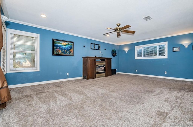 unfurnished living room with ceiling fan, ornamental molding, and carpet floors