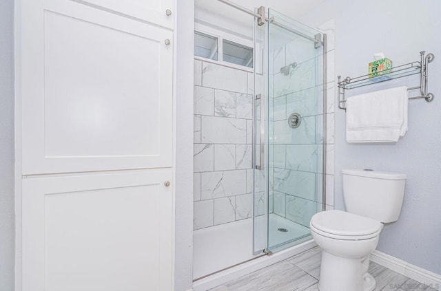 bathroom with an enclosed shower and toilet