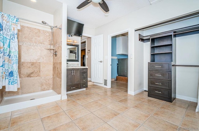 bathroom with ceiling fan, vanity, a shower with curtain, and tile patterned floors