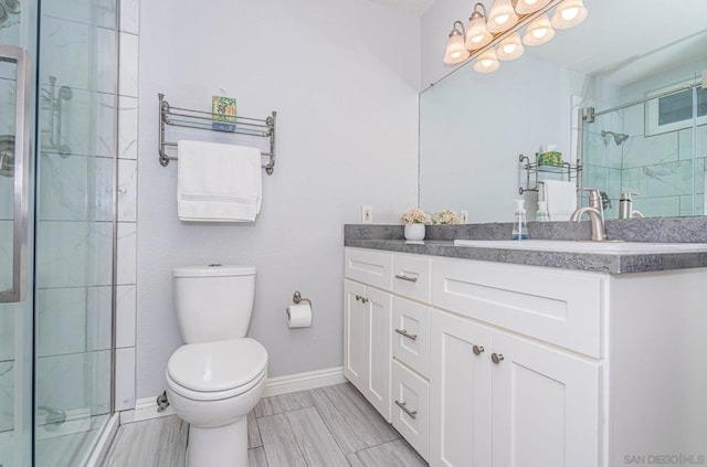 bathroom featuring a shower with shower door, vanity, and toilet