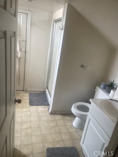 bathroom featuring toilet, a shower with shower door, and vanity