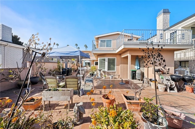 back of property with a balcony and a patio