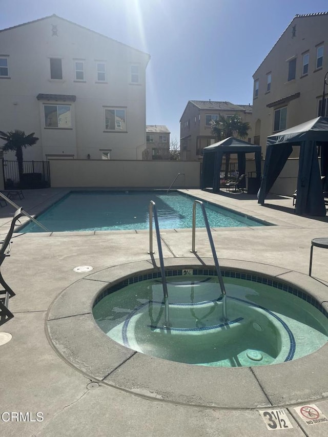 view of pool featuring a gazebo, a patio, and a hot tub