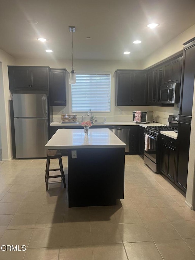 kitchen with light tile patterned floors, a center island, stainless steel appliances, and hanging light fixtures