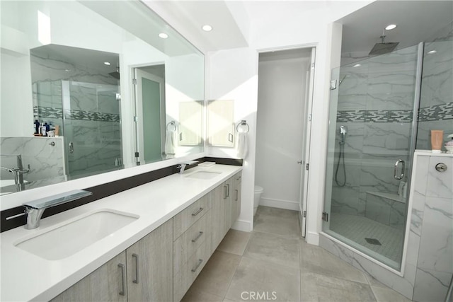 bathroom featuring tile patterned floors, an enclosed shower, vanity, and toilet