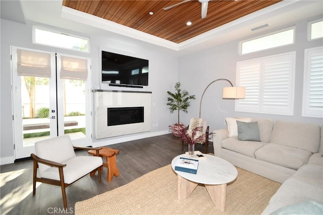 living room featuring dark wood-type flooring, ceiling fan, wood ceiling, and a tray ceiling