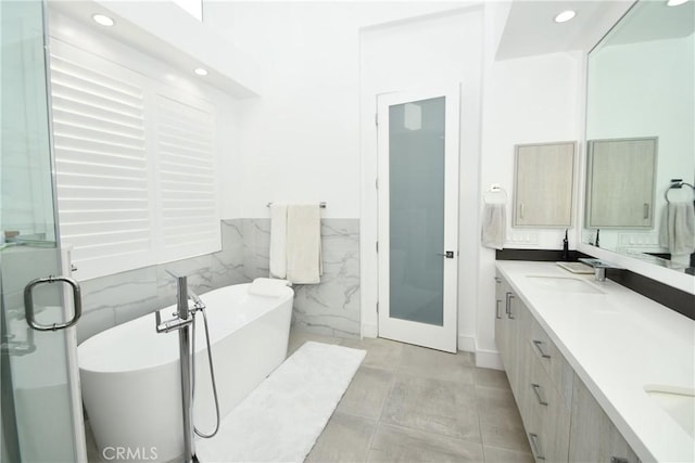 bathroom with shower with separate bathtub, tile walls, and vanity