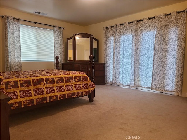 bedroom with visible vents and light colored carpet