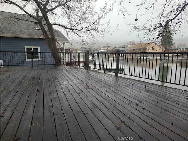 wooden terrace with a water view and a residential view