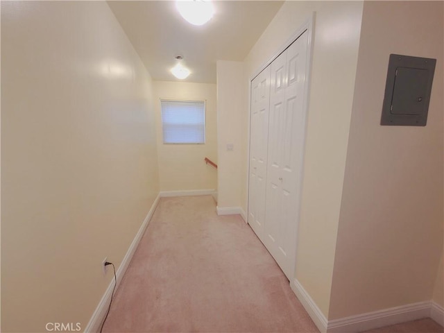 hall featuring baseboards, an upstairs landing, electric panel, and light colored carpet