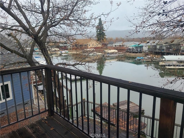 wooden terrace featuring a dock, a water view, and a residential view