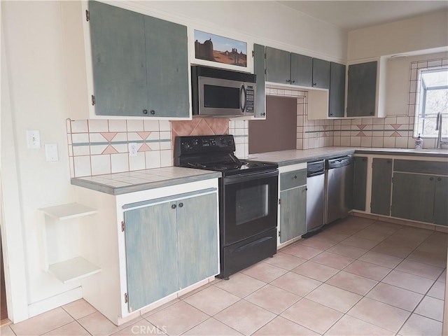 kitchen with stainless steel appliances, light tile patterned flooring, sink, and backsplash