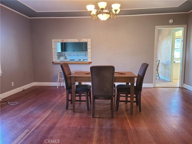 dining space with ornamental molding, a notable chandelier, and dark hardwood / wood-style floors