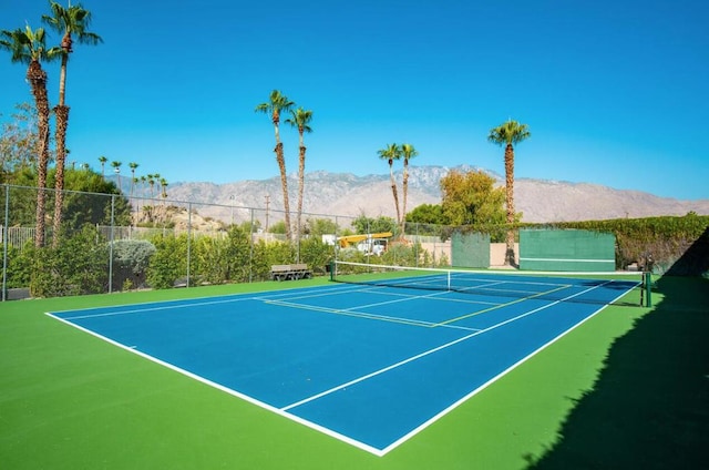 view of sport court featuring a mountain view and basketball hoop