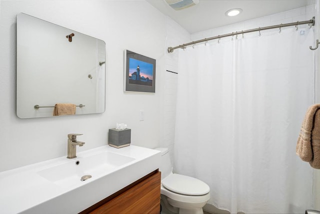 bathroom with toilet, vanity, and a shower with curtain