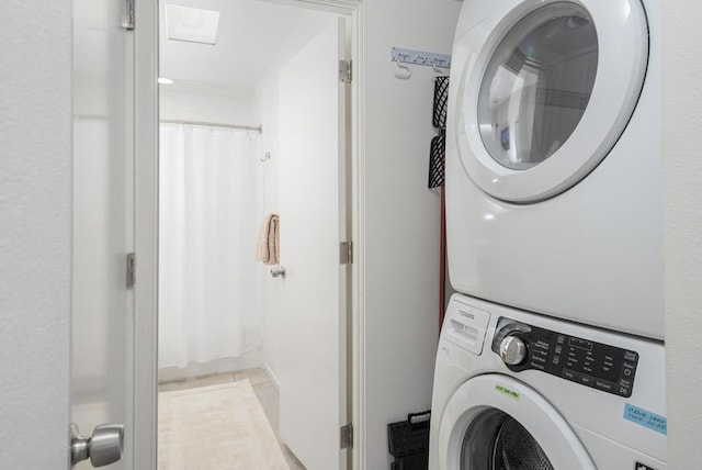 clothes washing area featuring stacked washing maching and dryer