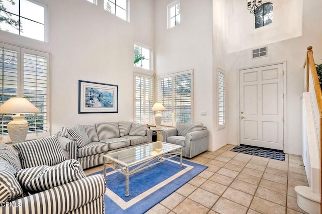 tiled living room featuring a towering ceiling and a healthy amount of sunlight