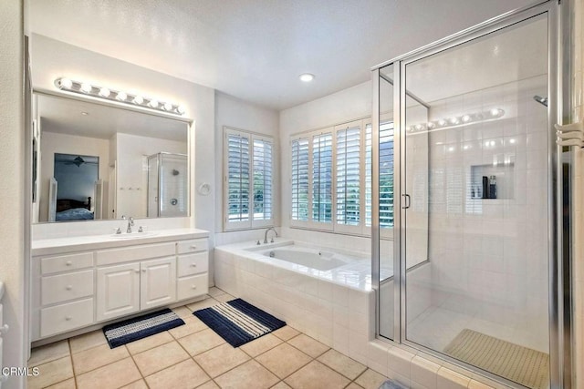 bathroom with tile patterned floors, shower with separate bathtub, and vanity