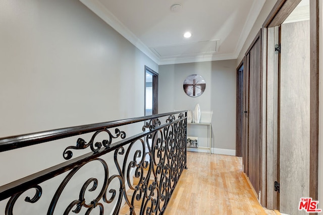 corridor featuring light wood-type flooring and crown molding