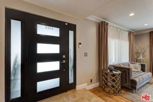 entrance foyer with light wood-type flooring and ornamental molding