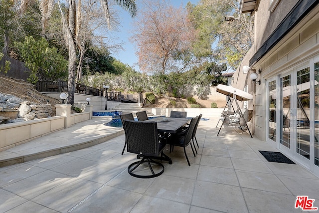 view of patio / terrace featuring a swimming pool and french doors