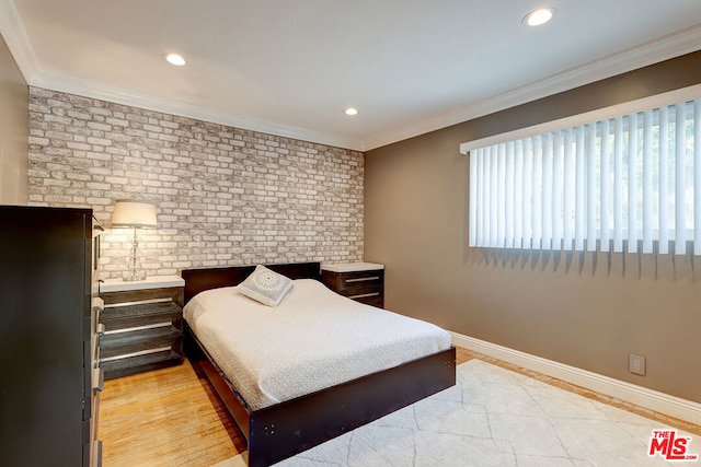 bedroom featuring light wood-type flooring, brick wall, and ornamental molding