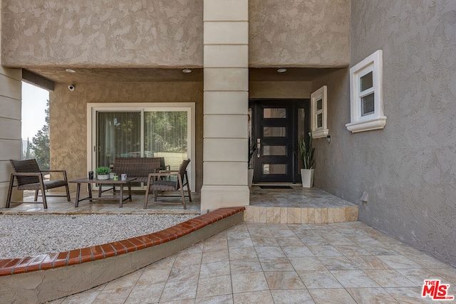 view of exterior entry featuring a patio area and outdoor lounge area