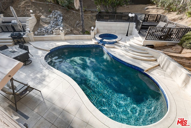 view of swimming pool with an in ground hot tub and a patio