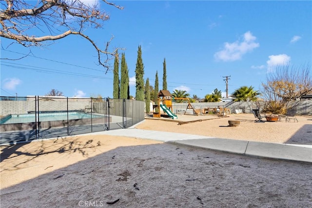 exterior space with a playground and a fenced in pool