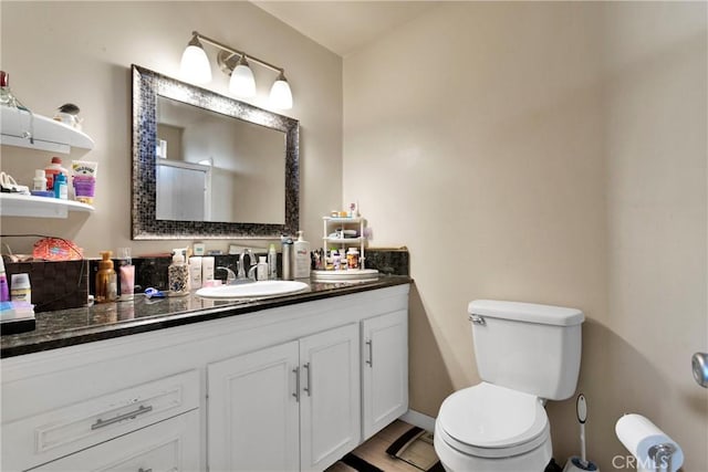 bathroom with toilet, vanity, and an enclosed shower