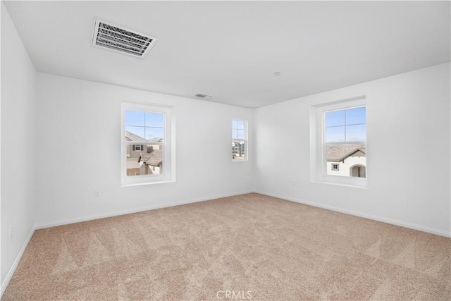 unfurnished room featuring light carpet