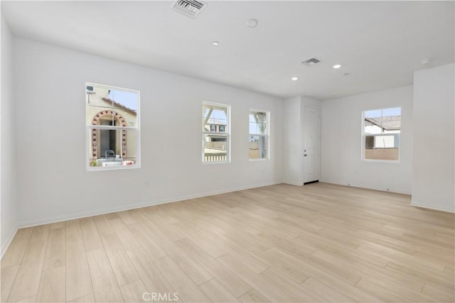 spare room featuring a wealth of natural light and light wood-type flooring