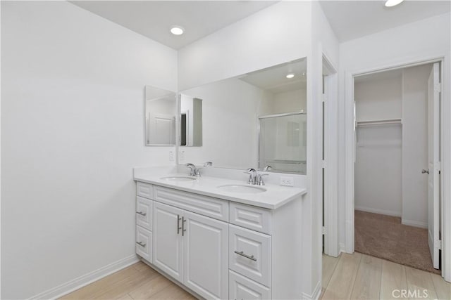 bathroom featuring walk in shower and vanity