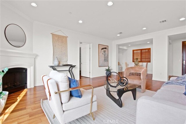 living room featuring ornamental molding and light hardwood / wood-style floors