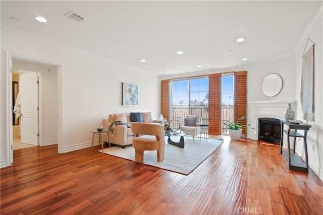 living room with wood-type flooring and crown molding