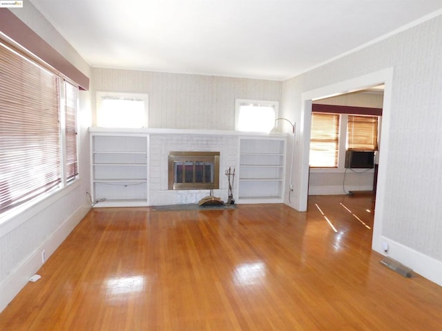 unfurnished living room featuring a brick fireplace and hardwood / wood-style flooring