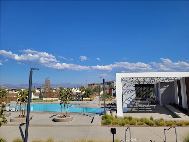 view of swimming pool featuring a patio area and a mountain view