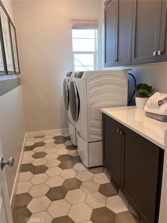 laundry area with washer and dryer, cabinets, and light tile patterned flooring