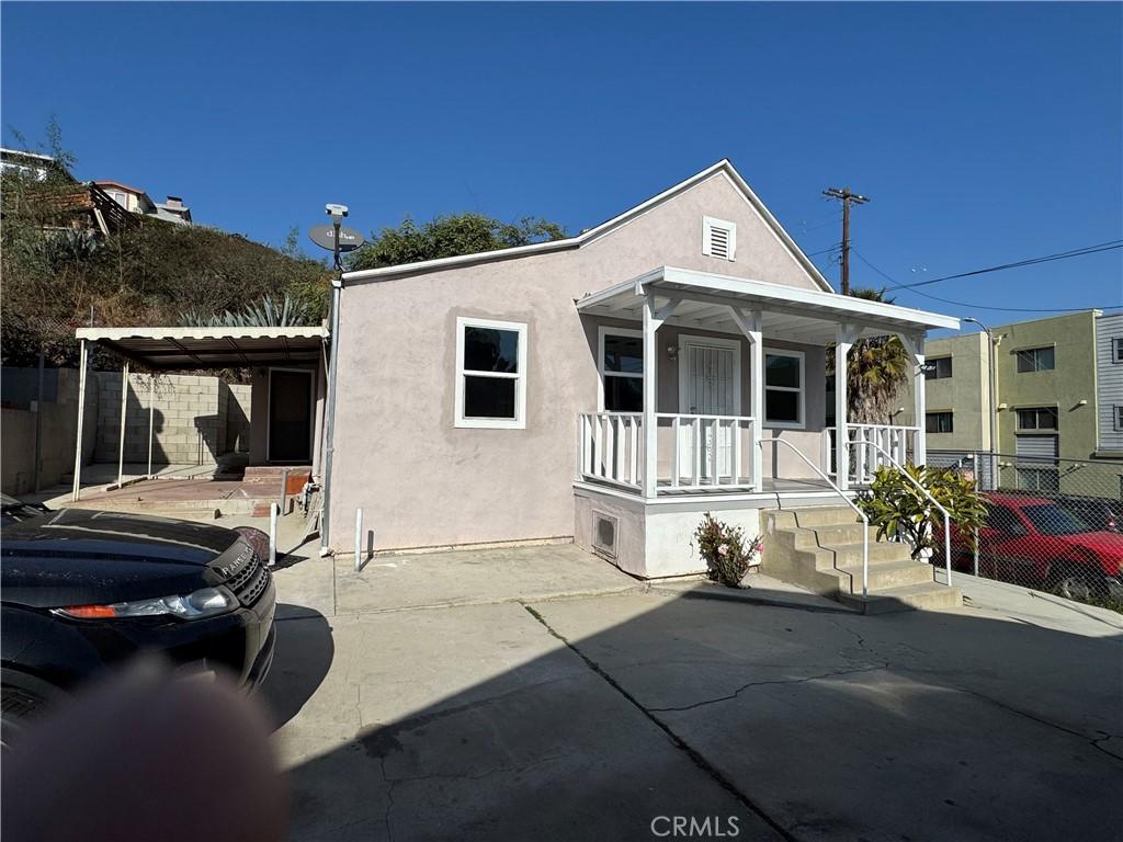 view of front of property with a porch and a carport