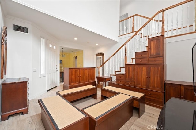 interior space with arched walkways, recessed lighting, visible vents, light wood-style flooring, and stairs