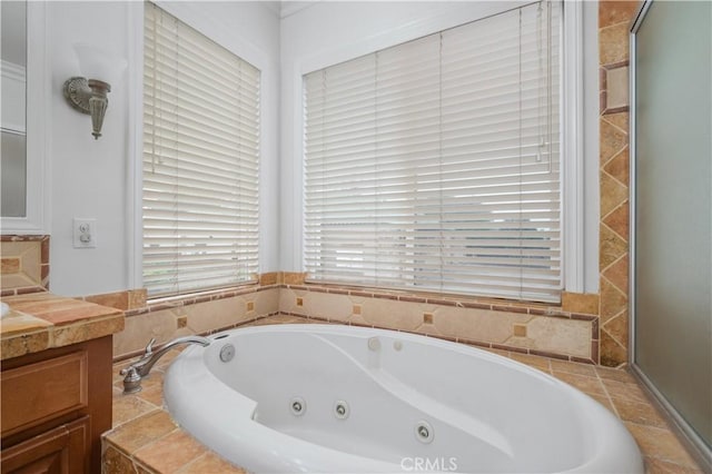 bathroom with a tub with jets and vanity