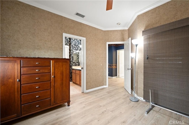 spare room featuring light wood-style floors, baseboards, visible vents, and crown molding