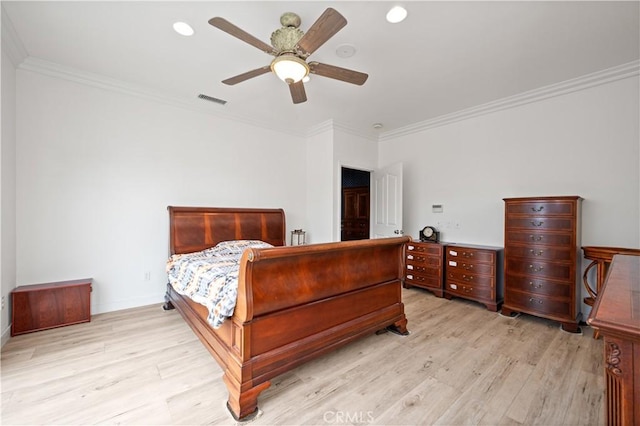 bedroom featuring ornamental molding, light wood finished floors, visible vents, and baseboards