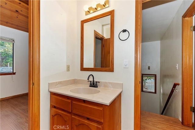 bathroom featuring wood-type flooring, lofted ceiling, and vanity