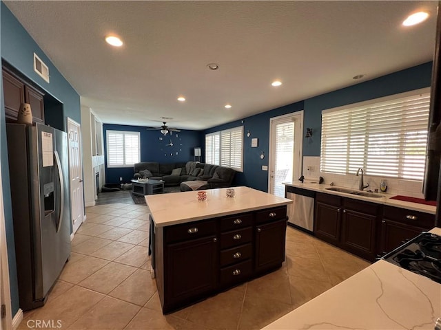 kitchen featuring ceiling fan, sink, appliances with stainless steel finishes, and light tile patterned flooring