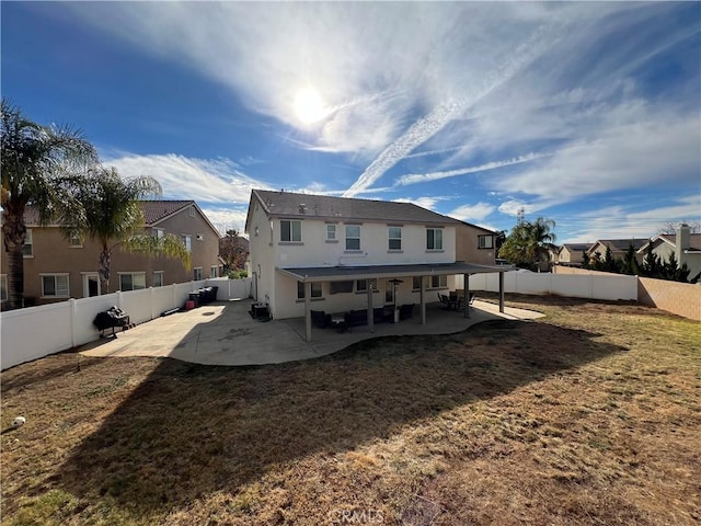 back of property with a lawn and a patio