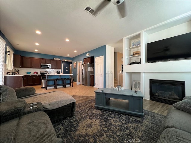 living room featuring ceiling fan and hardwood / wood-style flooring