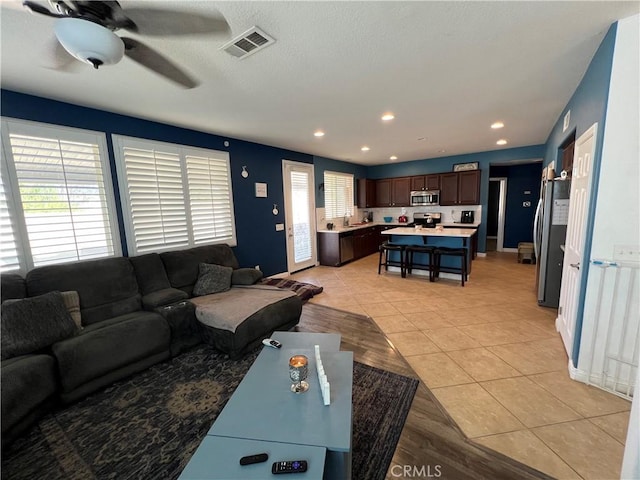 tiled living room featuring ceiling fan