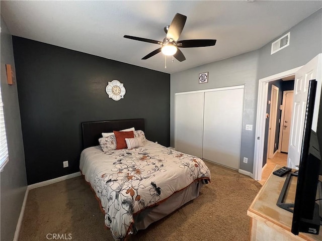 bedroom with light carpet, ceiling fan, and a closet