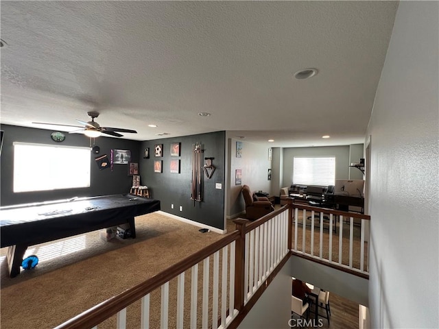 interior space featuring ceiling fan, carpet, billiards, and a textured ceiling